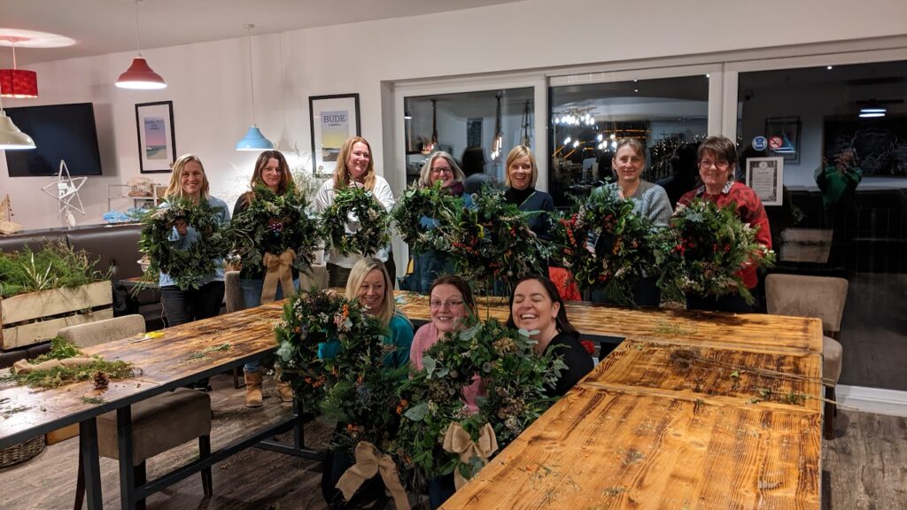 Room of people holding Christmas wreaths